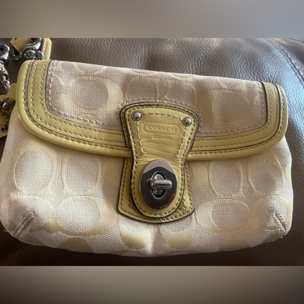 Classic and chic, refine your  Signature small wristlet with crossbody strap